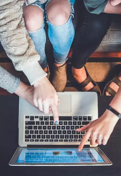 people pointing at a macbook